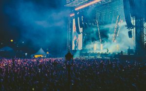 image of a live concert with a massive crowd cheering an artist on stage